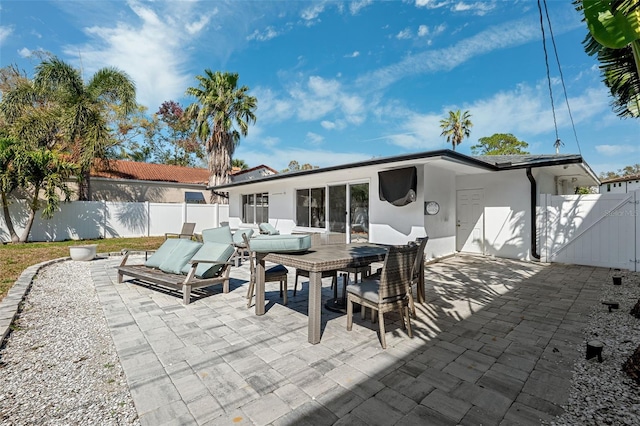 rear view of property with an outdoor living space and a patio area