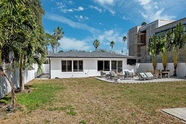 back of house with a patio and a lawn