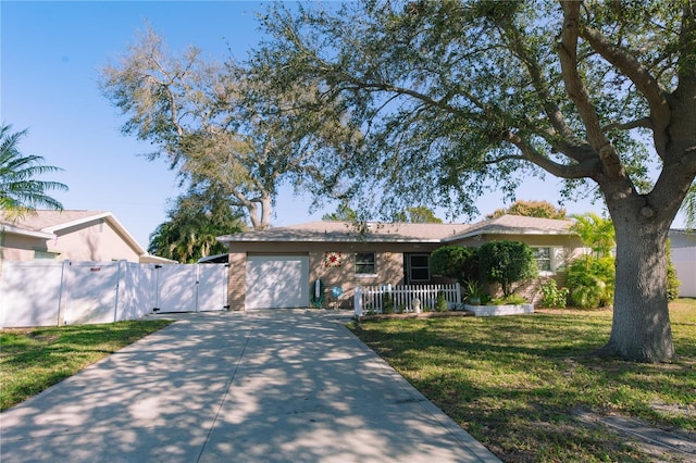 ranch-style home with concrete driveway, an attached garage, fence, and a front yard