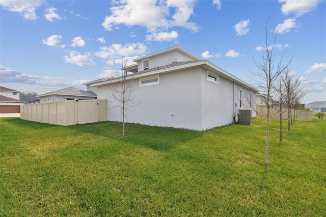 back of house with central AC and a lawn