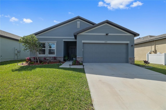 view of front of home featuring an attached garage, stone siding, driveway, and a front yard