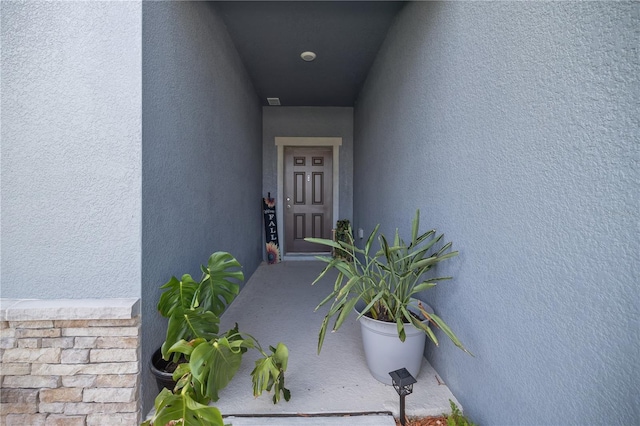 entrance to property featuring stucco siding