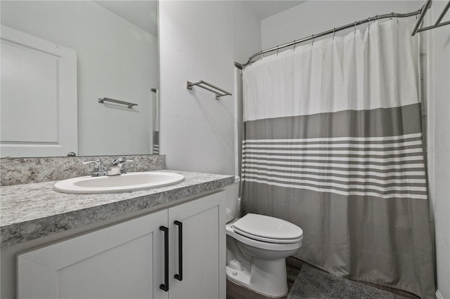 bathroom with toilet, curtained shower, and vanity