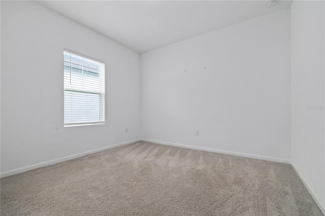 unfurnished room with carpet floors and baseboards