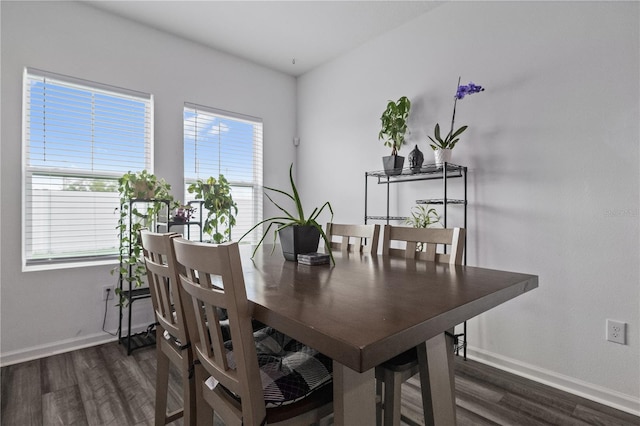 dining area featuring dark wood-style flooring and baseboards