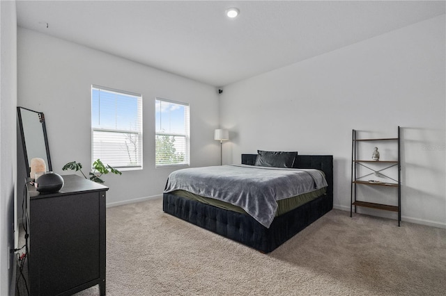 bedroom featuring light carpet and baseboards