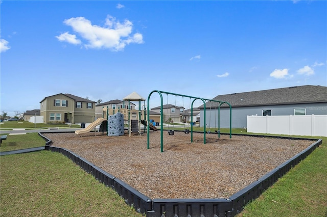 community playground with a residential view, fence, and a lawn