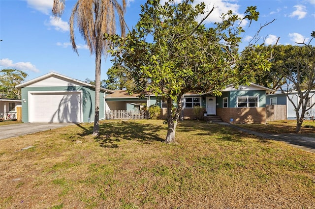 view of front facade featuring a front yard, fence, an attached garage, concrete driveway, and brick siding