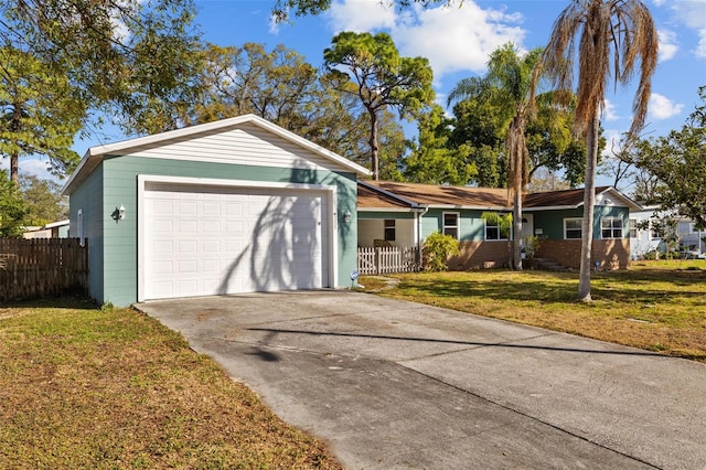 ranch-style house featuring a front yard, an attached garage, fence, and concrete driveway