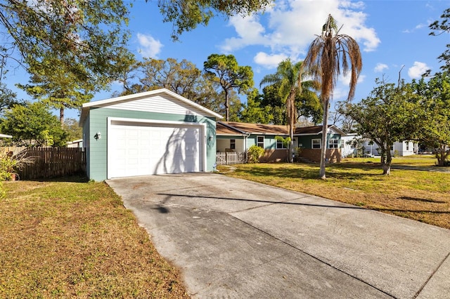 ranch-style house with a front lawn, concrete driveway, fence, and an attached garage