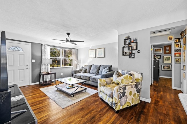 living room featuring baseboards, a textured ceiling, ceiling fan, and wood finished floors