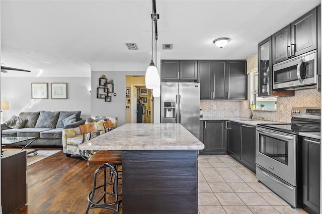 kitchen featuring tasteful backsplash, light tile patterned floors, visible vents, and appliances with stainless steel finishes