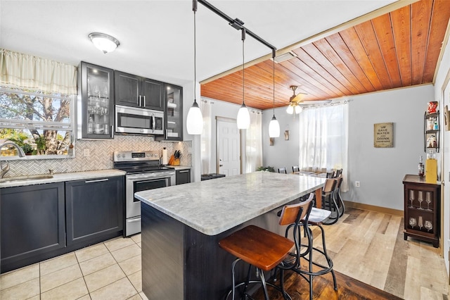 kitchen featuring a sink, decorative backsplash, a healthy amount of sunlight, and stainless steel appliances