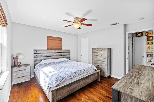 bedroom with dark wood finished floors, visible vents, baseboards, and a ceiling fan