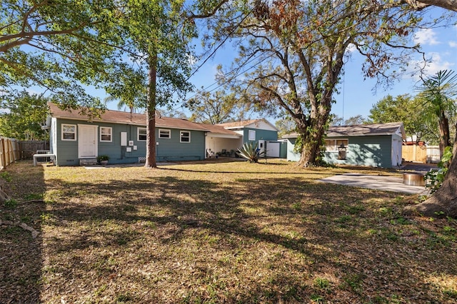 back of house featuring a lawn and fence