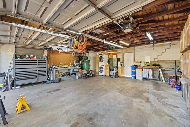 garage with a workshop area, stacked washer and clothes dryer, a garage door opener, and concrete block wall