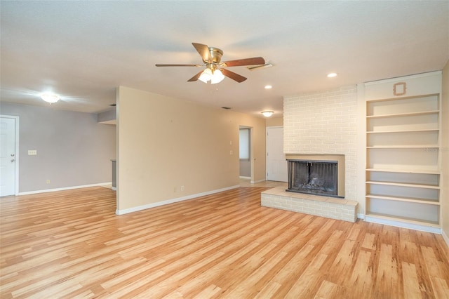 unfurnished living room featuring ceiling fan, a fireplace, baseboards, built in features, and light wood-type flooring