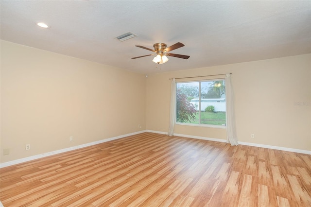 unfurnished room with a ceiling fan, light wood-style flooring, visible vents, and baseboards