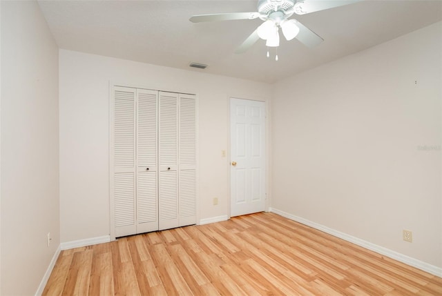 unfurnished bedroom featuring baseboards, a closet, visible vents, and light wood-style floors