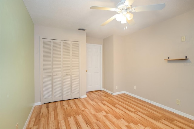 unfurnished bedroom with baseboards, a closet, visible vents, and light wood-style floors