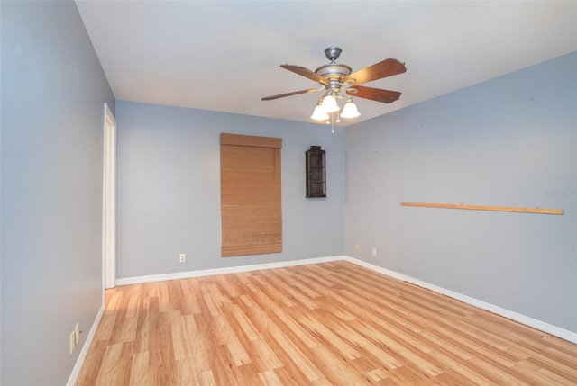 spare room with ceiling fan, light wood finished floors, and baseboards