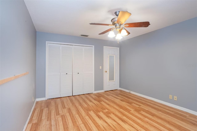 unfurnished bedroom with a closet, visible vents, light wood-style flooring, ceiling fan, and baseboards