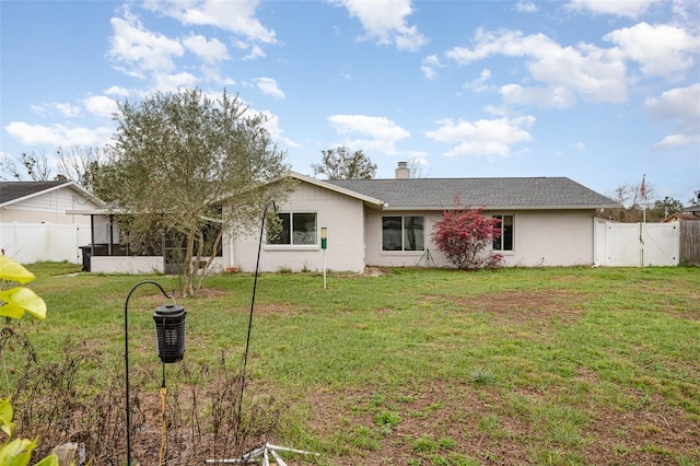 ranch-style home featuring a front lawn, fence, and a gate