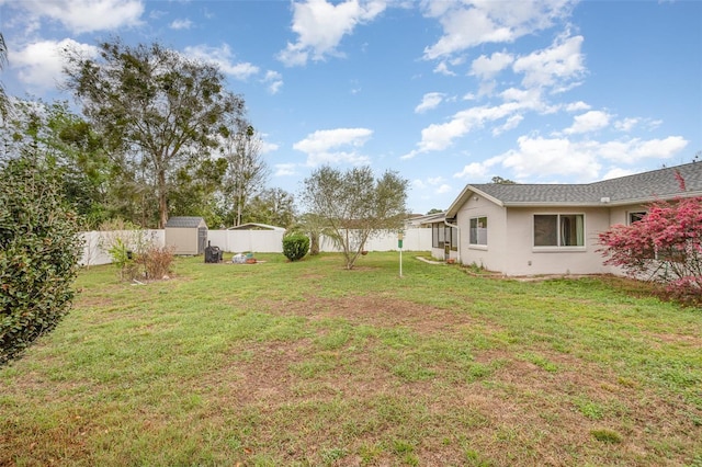 view of yard with a fenced backyard, an outdoor structure, and a shed