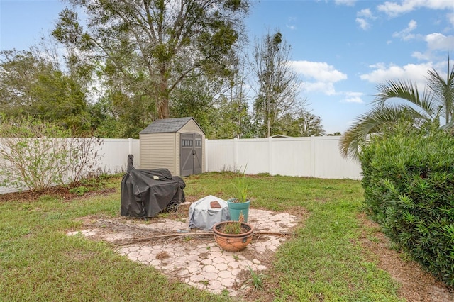 view of yard with a storage shed, an outbuilding, and a fenced backyard