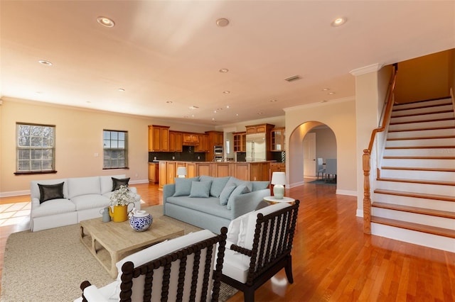 living room with crown molding and light hardwood / wood-style flooring