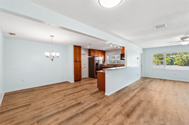 1119 77th St N, Saint Petersburg, FL 33710 - kitchen featuring visible vents, brown cabinets, stainless steel fridge, light wood-style floors, and open floor plan