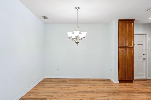 1119 77th St N, Saint Petersburg, FL 33710 - unfurnished room featuring light wood finished floors, visible vents, baseboards, and a notable chandelier