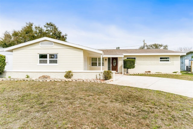 single story home featuring driveway, a front lawn, and brick siding