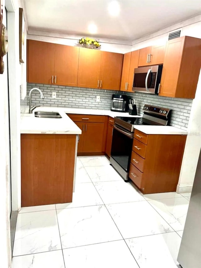 kitchen featuring appliances with stainless steel finishes, sink, and decorative backsplash