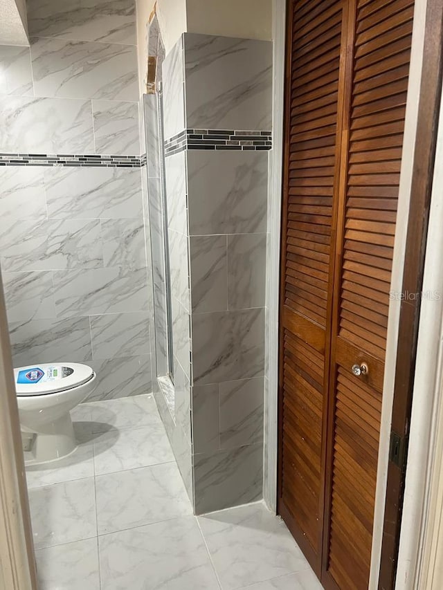 bathroom featuring toilet and tiled shower