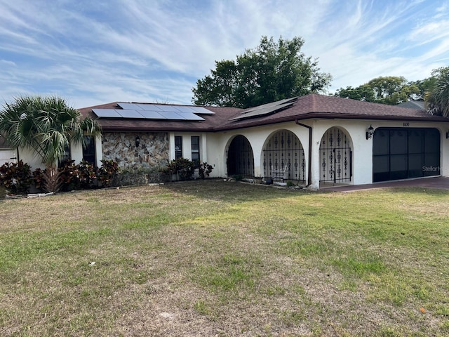 8630 Winter Haven Dr, Hudson, FL 34667 - view of front of home with a garage, a front yard, solar panels, and stucco siding