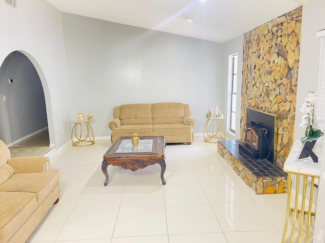 8630 Winter Haven Dr, Hudson, FL 34667 - tiled living area featuring a wood stove, arched walkways, and baseboards