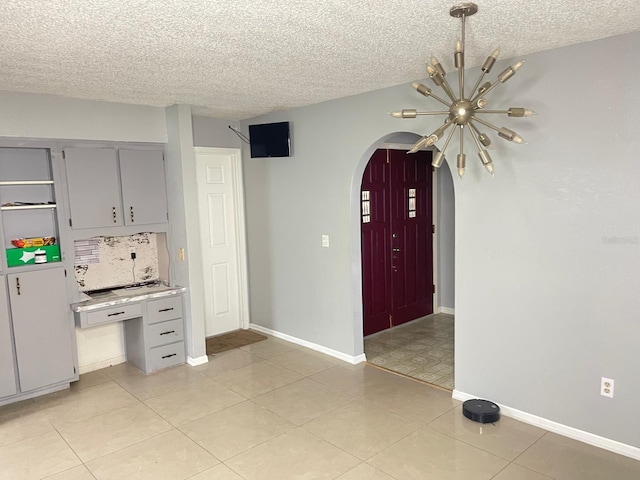 8630 Winter Haven Dr, Hudson, FL 34667 - kitchen with arched walkways, a textured ceiling, gray cabinetry, baseboards, and light countertops