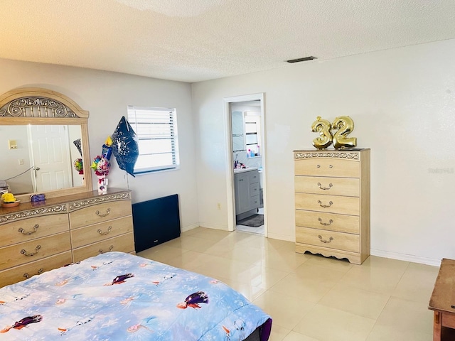 8630 Winter Haven Dr, Hudson, FL 34667 - bedroom featuring light tile patterned floors, a textured ceiling, ensuite bath, and baseboards