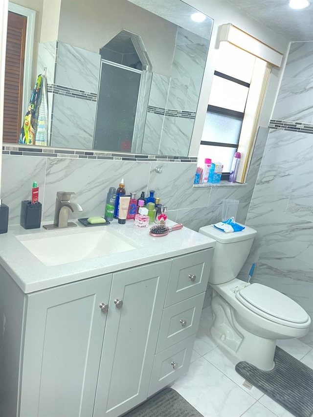 8630 Winter Haven Dr, Hudson, FL 34667 - bathroom with tile walls, marble look tiles, toilet, and vanity
