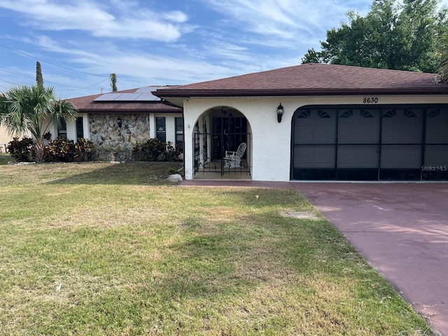 8630 Winter Haven Dr, Hudson, FL 34667 - single story home featuring a front lawn, roof mounted solar panels, stucco siding, a garage, and driveway