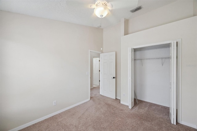 unfurnished bedroom with baseboards, visible vents, a closet, a textured ceiling, and carpet flooring