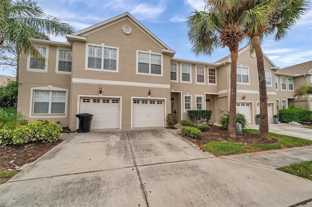 multi unit property with stucco siding, driveway, and an attached garage