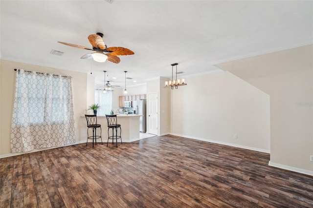 unfurnished living room with visible vents, baseboards, ornamental molding, ceiling fan with notable chandelier, and dark wood-style flooring