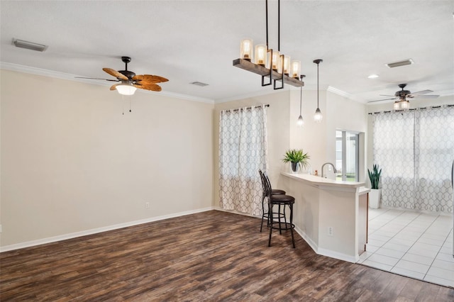 kitchen featuring visible vents, ceiling fan, and ornamental molding