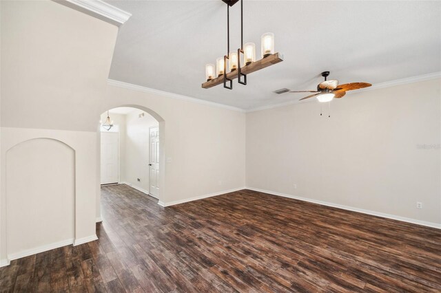 empty room with visible vents, dark wood finished floors, arched walkways, ornamental molding, and ceiling fan