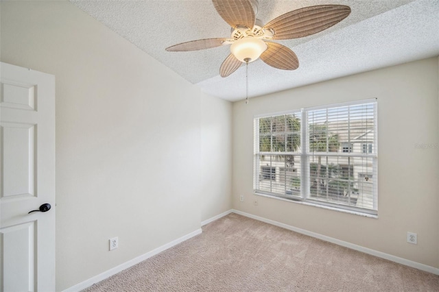 unfurnished room featuring baseboards, light colored carpet, and a textured ceiling