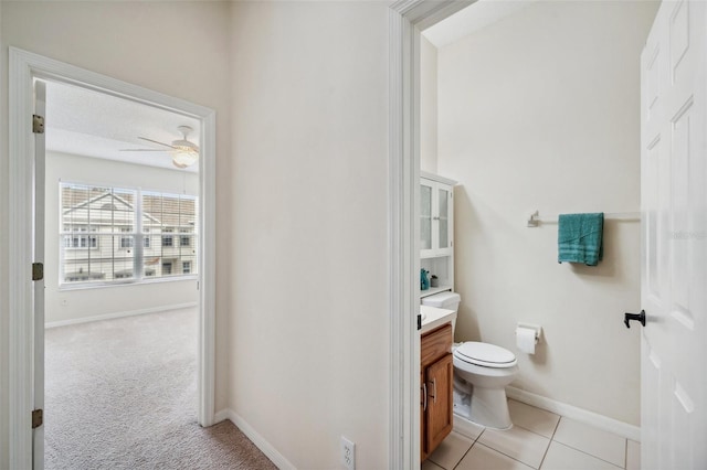 bathroom featuring vanity, toilet, a ceiling fan, and baseboards