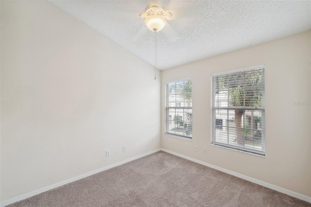 unfurnished room featuring vaulted ceiling, carpet, baseboards, and ceiling fan