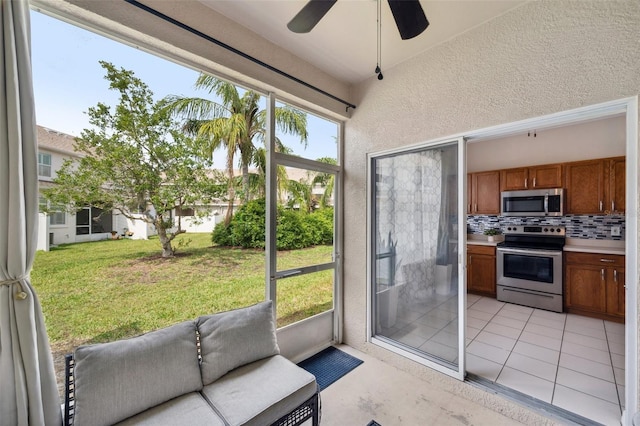 sunroom / solarium featuring a ceiling fan